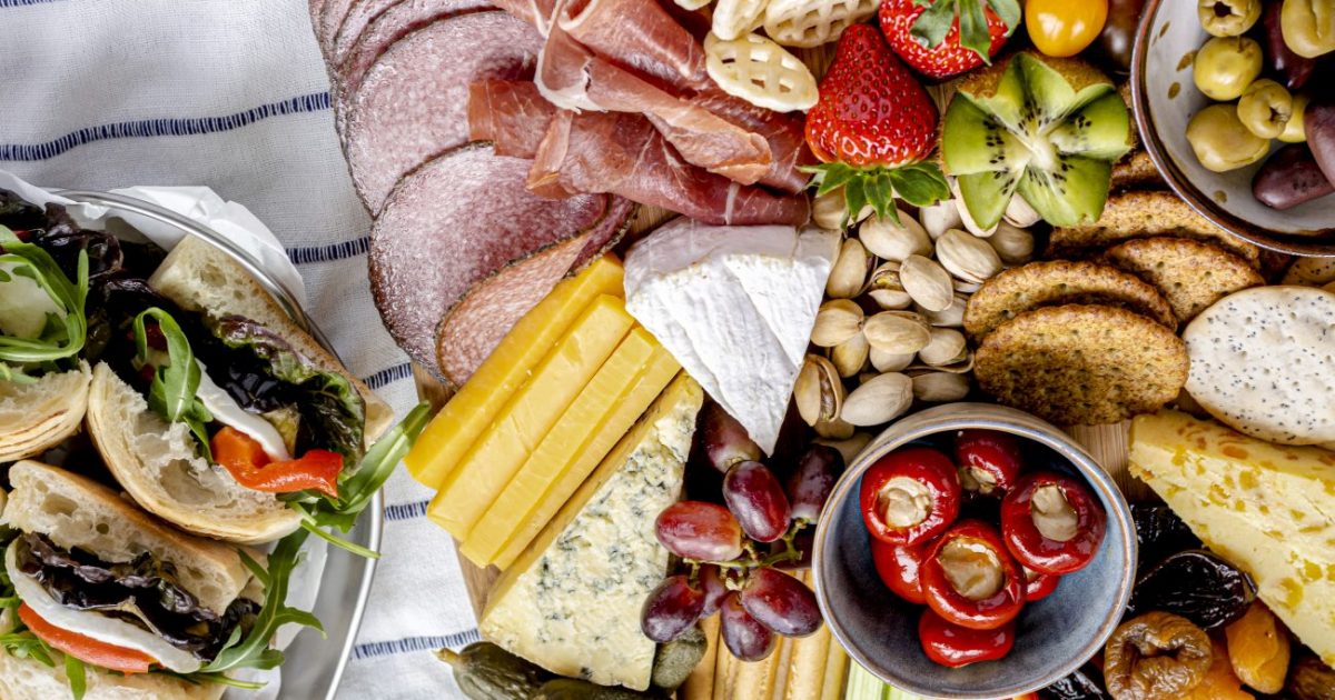 Charcuterie board with cold cuts, fresh fruits and cheese, summer picnic